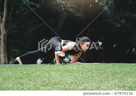 Asian woman practicing yoga on mat in outdoor 67974316