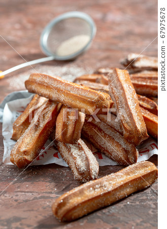 Traditional churros sprinkled with sugar and 67975678