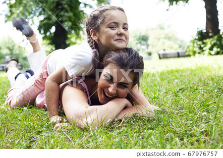 young pretty mother walking with little cute daughter outside in green park, lifestyle poeple concept 67976757