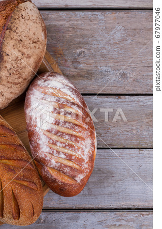 Delicious fresh bread on wooden background. 67977046