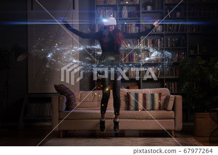 Woman is using virtual reality headset. Elements of this image furnished by NASA. 67977264