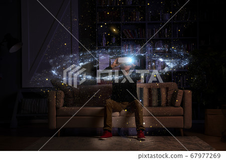 Man uses virtual reality glasses to see the galaxy space. Elements of this image furnished by NASA. 67977269