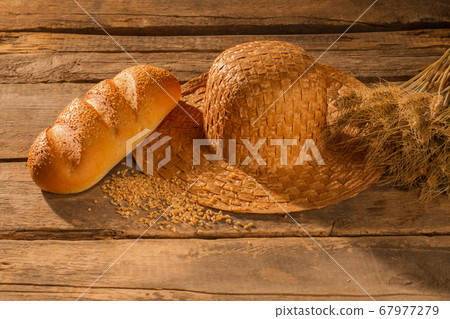 Wheat grain, baguette, straw hat and spikelets. 67977279