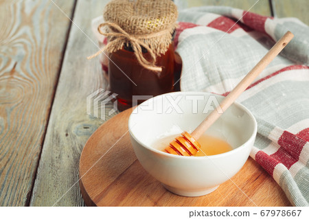 Honey background. Sweet honey in glass jar on wooden background. 67978667