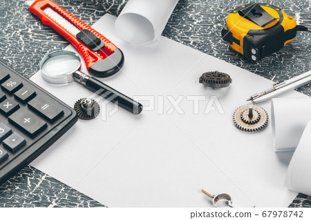 safety helmet and Scrolls of engineering drawings and supplies 67978742