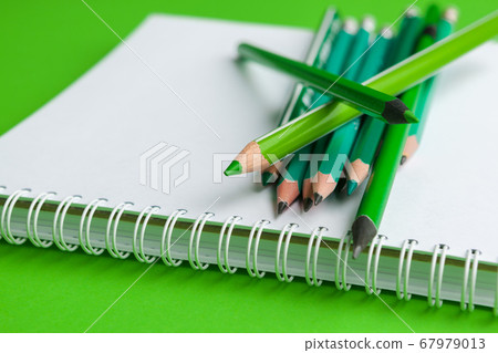 Heap of pencils on a bright green background Heap of pencils on a bright green background 67979013