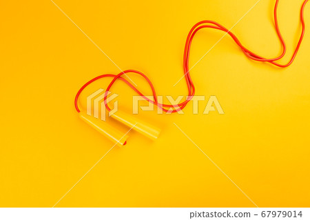 Jumping rope on yellow background. creative photo. Jumping rope on yellow background. creative photo. 67979014