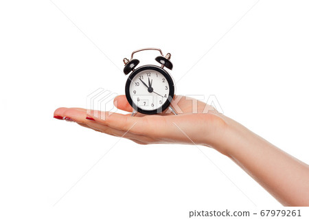 Female hand holding alarm clock on white background 67979261