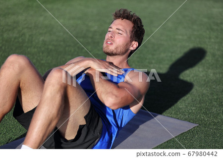 Fit man training at fitness gym doing situp crunches on exercise mat. Bodyweight floor exercises. Healthy and sport lifestyle. Man doing weight loss abs stomach exercise for ab muscles. 67980442