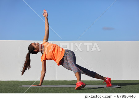 Yoga pose variation fitness girl doing the fallen triangle assited with leg. Asian woman doing side plank with lateral leg raise. Planking exercise for body core, bodyweight workout at home gym. Yoga pose variation fitness girl doing the fallen triangle assited with leg. Asian woman doing side plank with lateral leg raise. Planking exercise for body core, bodyweight workout at home gym. 67980446