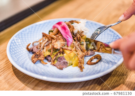 Danish food smorrebrod open sandwich woman eating at restaurant. Person using fork and knife cutting beef lunch meal from Denmark. Copenhagen city travel lifestyle. Closeup of plate. Danish food smorrebrod open sandwich woman eating at restaurant. Person using fork and knife cutting beef lunch meal from Denmark. Copenhagen city travel lifestyle. Closeup of plate. 67981130