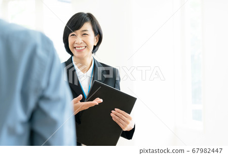 將設施引導給客戶的中年女性 將設施引導給客戶的中年女性 67982447