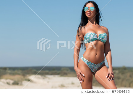 Beautiful woman in swimsuit on beach Beautiful woman in swimsuit on beach 67984455