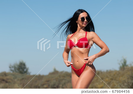 Beautiful woman in swimsuit on beach Beautiful woman in swimsuit on beach 67984456