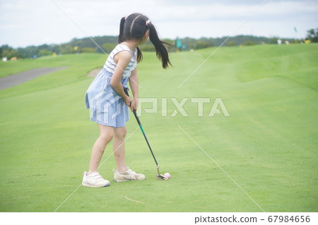 小學一年級女孩在主題樂園享受推桿高爾夫 67984656