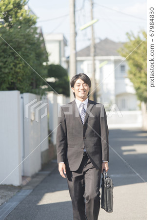 Businessman walking in town Businessman walking in town 67984830