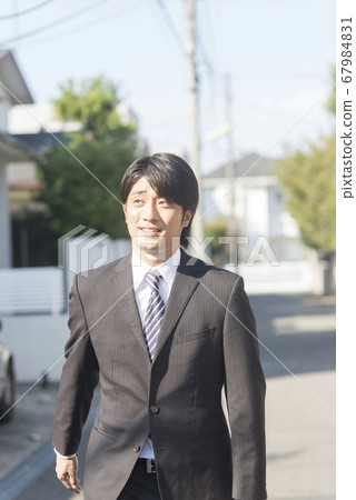 Businessman walking in town Businessman walking in town 67984831