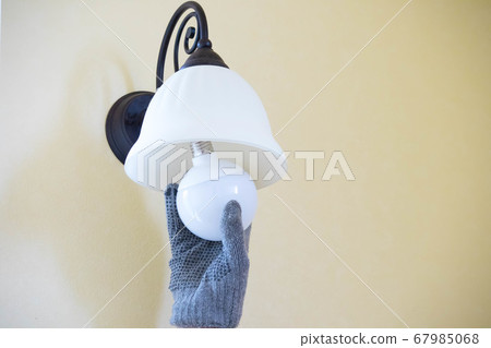 Lighting bulb replacement work with work gloves Lighting bulb replacement work with work gloves 67985068