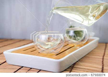 pours chinese green tea from glass kettle to small pours chinese green tea from glass kettle to small 67988074