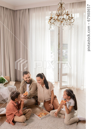 Happy family eating pizza on floor Happy family eating pizza on floor 67988657
