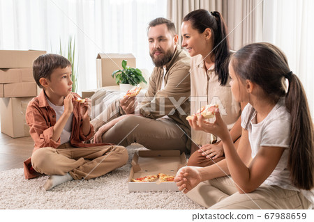 Friendly family eating pizza in new house Friendly family eating pizza in new house 67988659