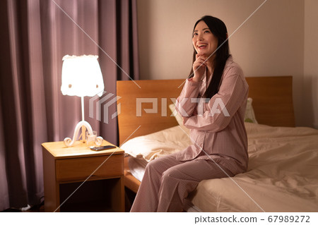 一個女人坐在床上 67989272