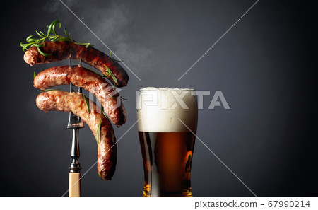 Beer and grilled Bavarian sausages with rosemary. Beer and grilled Bavarian sausages with rosemary. 67990214