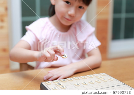 A girl playing shogi 67990758