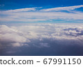 Aerial sky and fluffy clouds background. View from airplane porthole 67991150