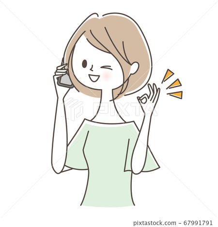 A woman giving an OK sign while talking on a smartphone 67991791