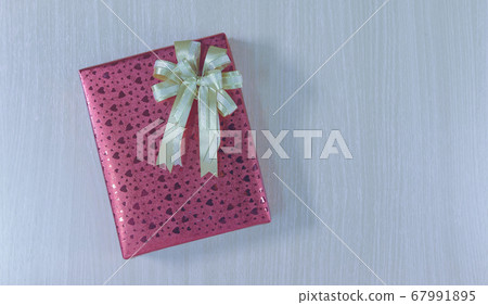 Top view on gift box with bow on wooden background with copy space Top view on gift box with bow on wooden background with copy space 67991895