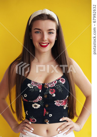 Sexy young girl with disheveled long brown hair wearing denim shorts with a high waist 67992632