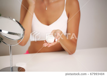 Young woman in a bathrobe, brings beauty in the bathroom Young woman in a bathrobe, brings beauty in the bathroom 67993484