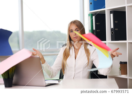 blonde throws paper woman in office, business concept 67993571