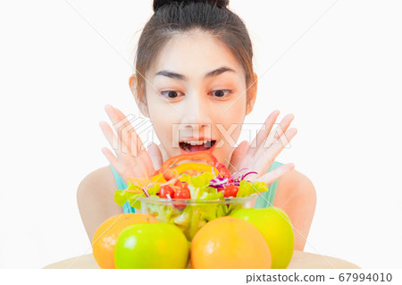 Young beautiful asian woman looking  a salad glass cup   excited isolated on white background 67994010