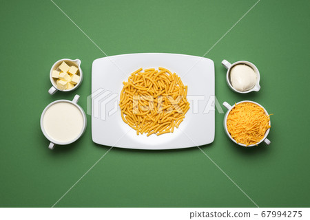 Mac and cheese ingredients on a green table. 67994275