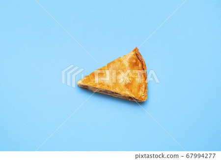 Apple pie slice isolated on blue color. Last piece 67994277