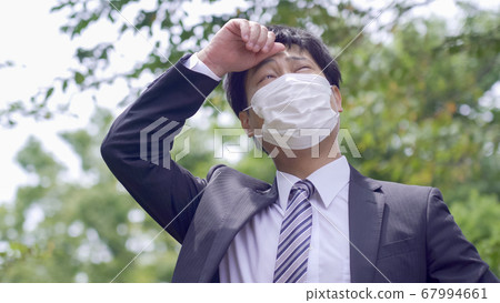 Businessman suffering from heat Businessman suffering from heat 67994661