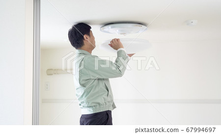 工人在天花板上安裝吸頂燈 67994697