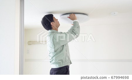 工人在天花板上安裝吸頂燈 工人在天花板上安裝吸頂燈 67994698