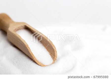 Salt grain in wooden spoon top view on a white background 67995080