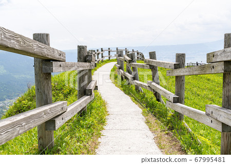 阿蘇山山頂的一條狹窄道路被木柵欄包圍 阿蘇山山頂的一條狹窄道路被木柵欄包圍 67995481