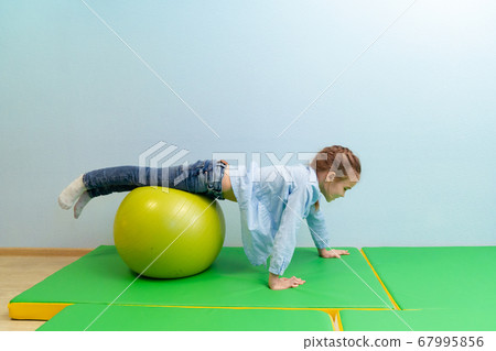 teen girl engaged in physical therapy on ball teen girl engaged in physical therapy on ball 67995856
