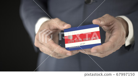 Businessman holding plastic bank card with printed flag of Costa Rica, fictional numbers 67997150