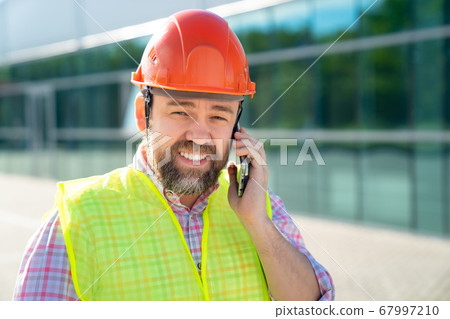inspector in construction helmet answer phone call inspector in construction helmet answer phone call 67997210