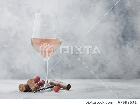 Glass of summer pink rose wine with grapes, corks Glass of summer pink rose wine with grapes, corks 67998631