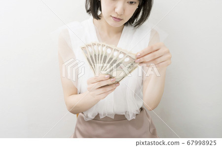 持有100,000日元固定收益的婦女的總體形象。 67998925