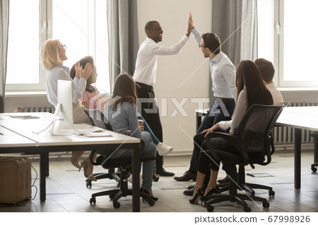 African American executive with colleague giving high five during briefing 67998926