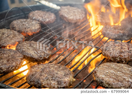 Juicy meat steaks cooked over charcoal on a wire rack 67999064