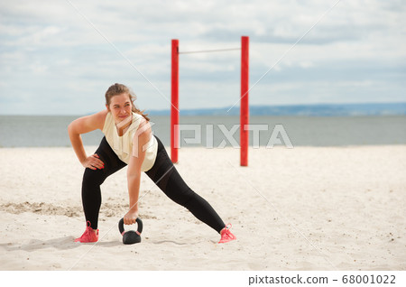 Portrait of positive woman wearing top and leggings warming up. 68001022